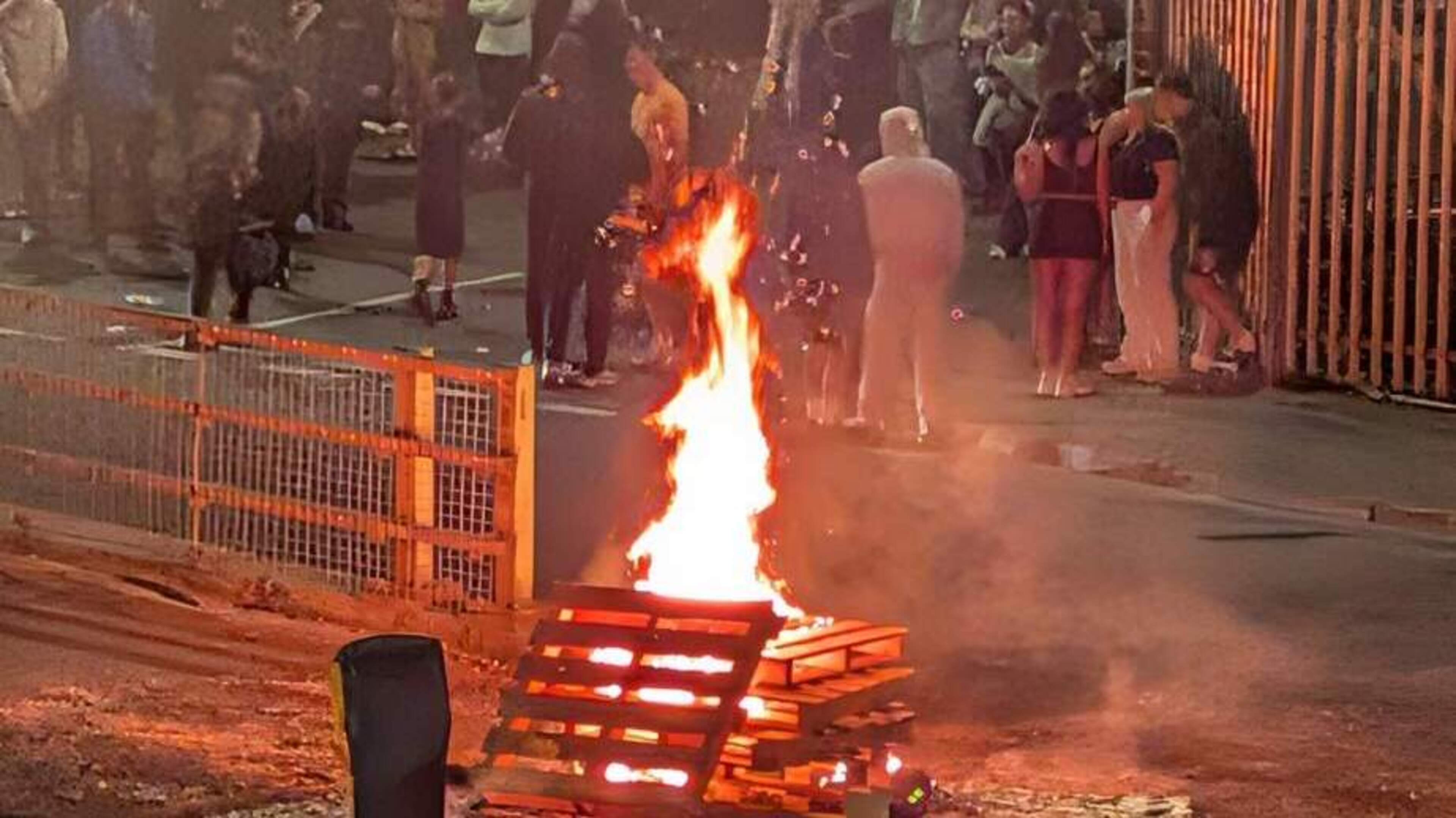 Fires lit in middle of the road in Derry as crowd gathers after removal of bonfire material